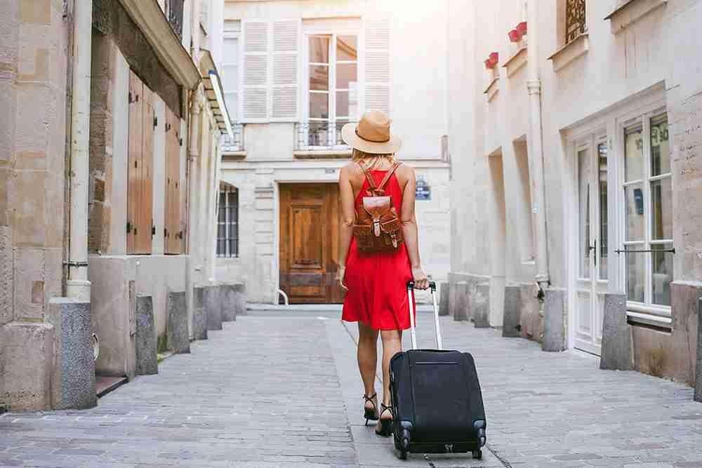 traveler walks to hotel with suitcase in Marais in paris